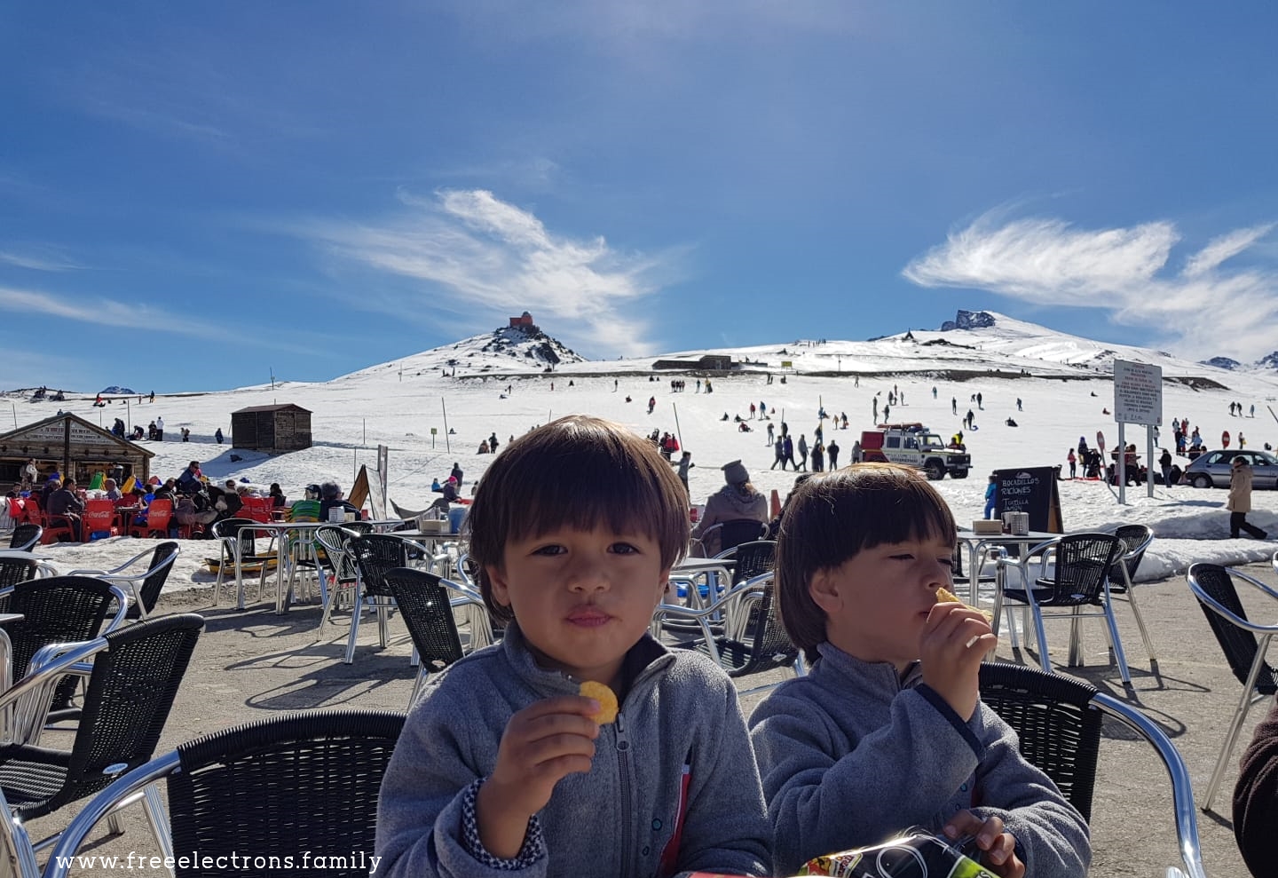 Two young boys sitting on lawn chairs, taking a break, eating "patata fritas" (chips) at one of a handful of alpujarran "chiringuito" (small open air bar/food shack)

www.freeelectrons.family