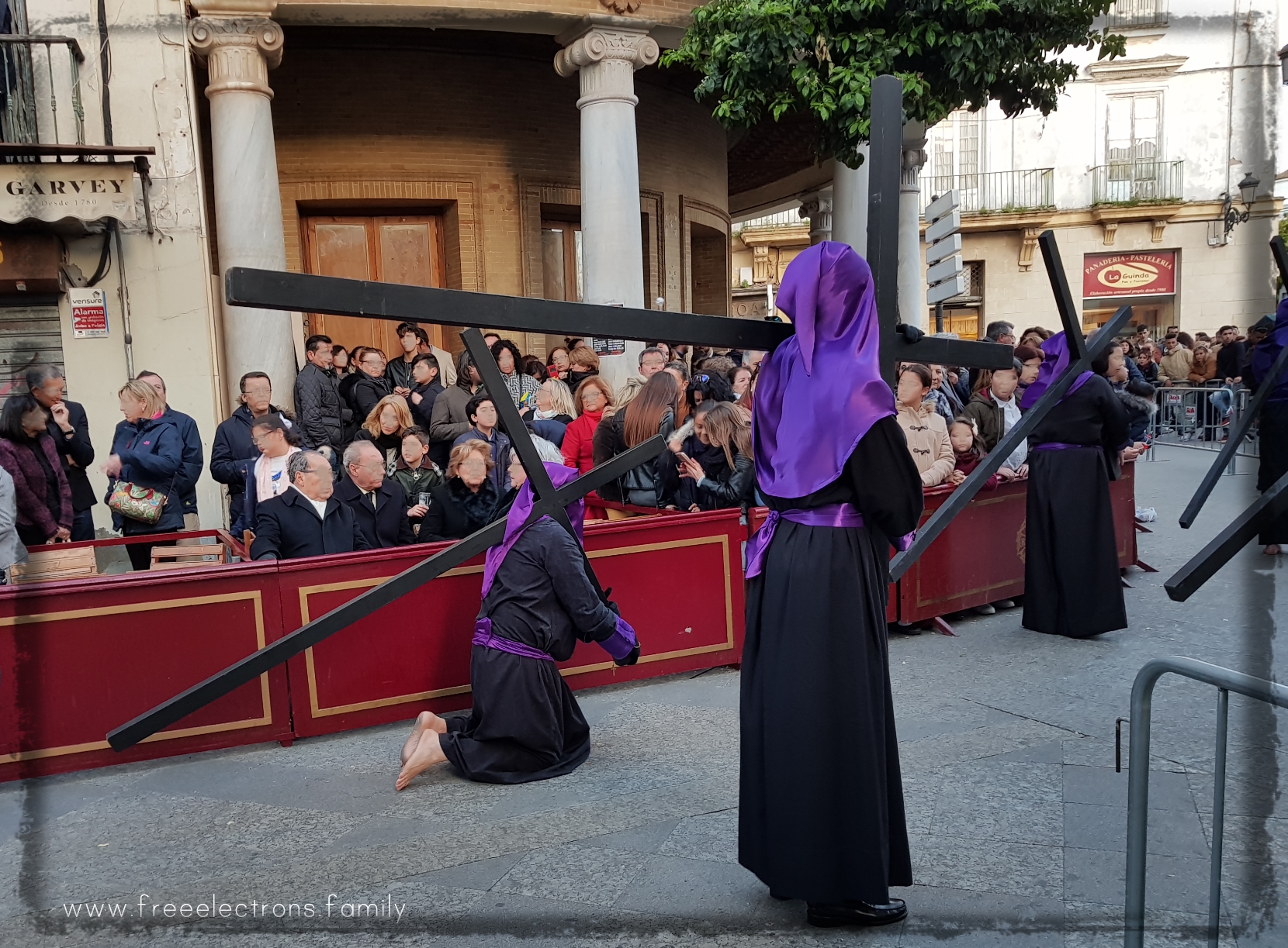 A cross-carrying procession during Holy Week (Semana Santa) along Calle Larga, Jerez de la Frontera, Spain.