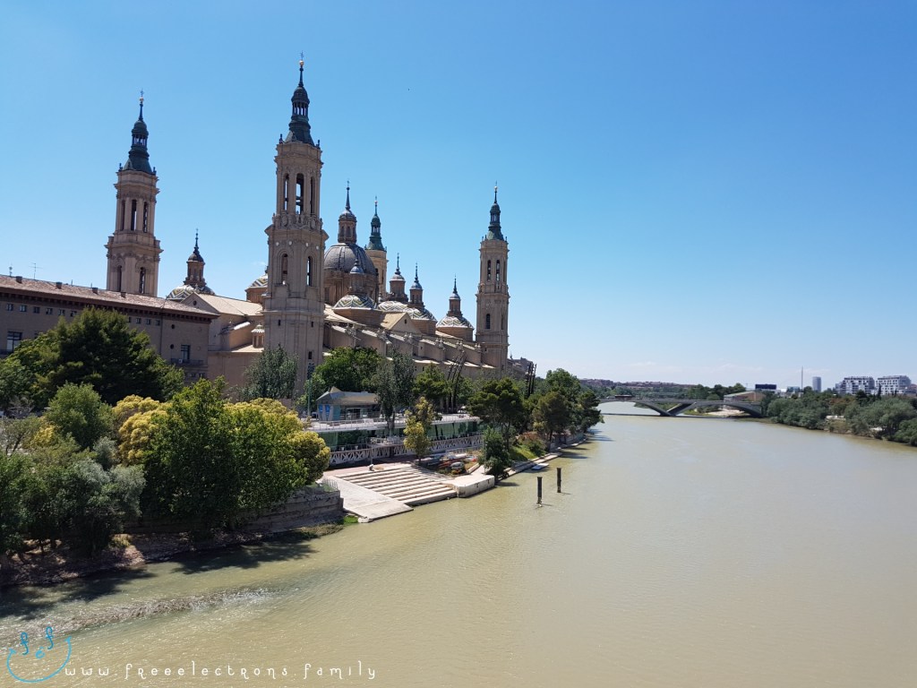 A view of the Catedral-Basílica de Nuestra Señora del Pilar (Cathedral-Basilica of Our Lady of the Pillar) from the Puente de Piedra (Stone Bridge) over the Ebro river. Third stop on our #FreeElectrons.Family summer camping road trip Europe, Day 5 in Zaragoza.