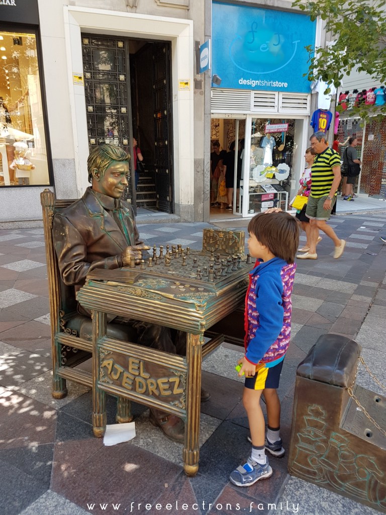 A young boy enjoying a game of "El Ajedrez" ... or chesss in a street of Madrid.