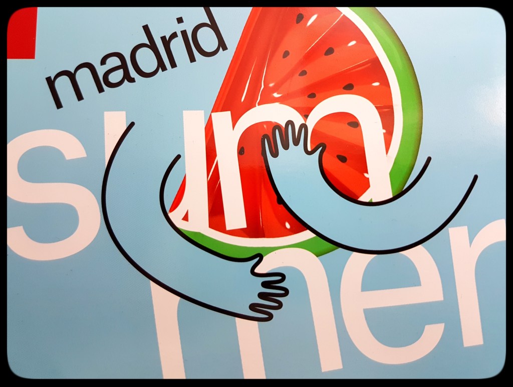 Madrid summer logo, arms hugging a watermelon to show:"Madrid Te Abraza!" from esMadrid.com magazine