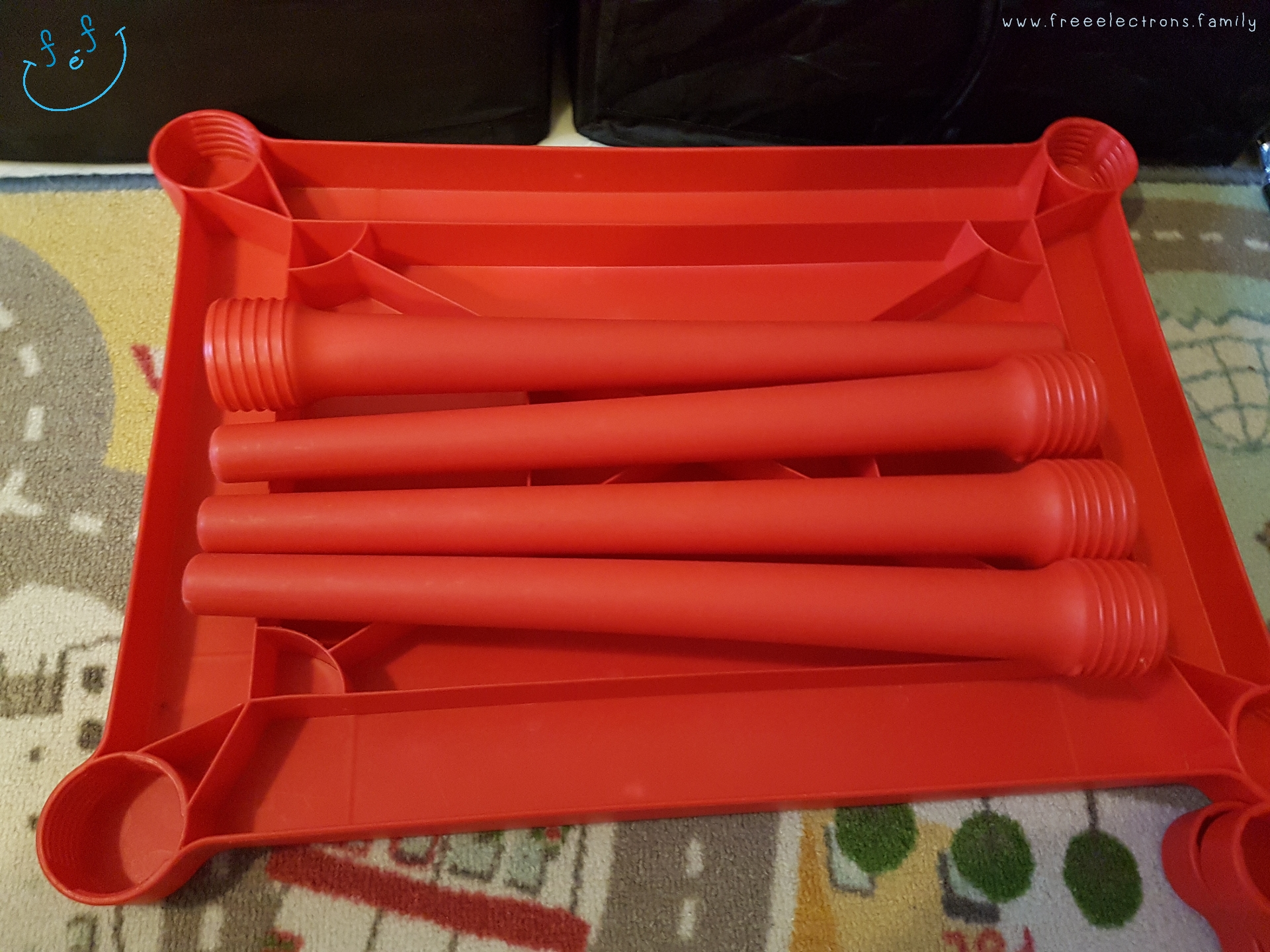 Collapsible red IKEA kiddie table for efficient packing.

Text reads: www.freeelectrons.family.

#FreeElectrons.Family - camping Europe, what to bring