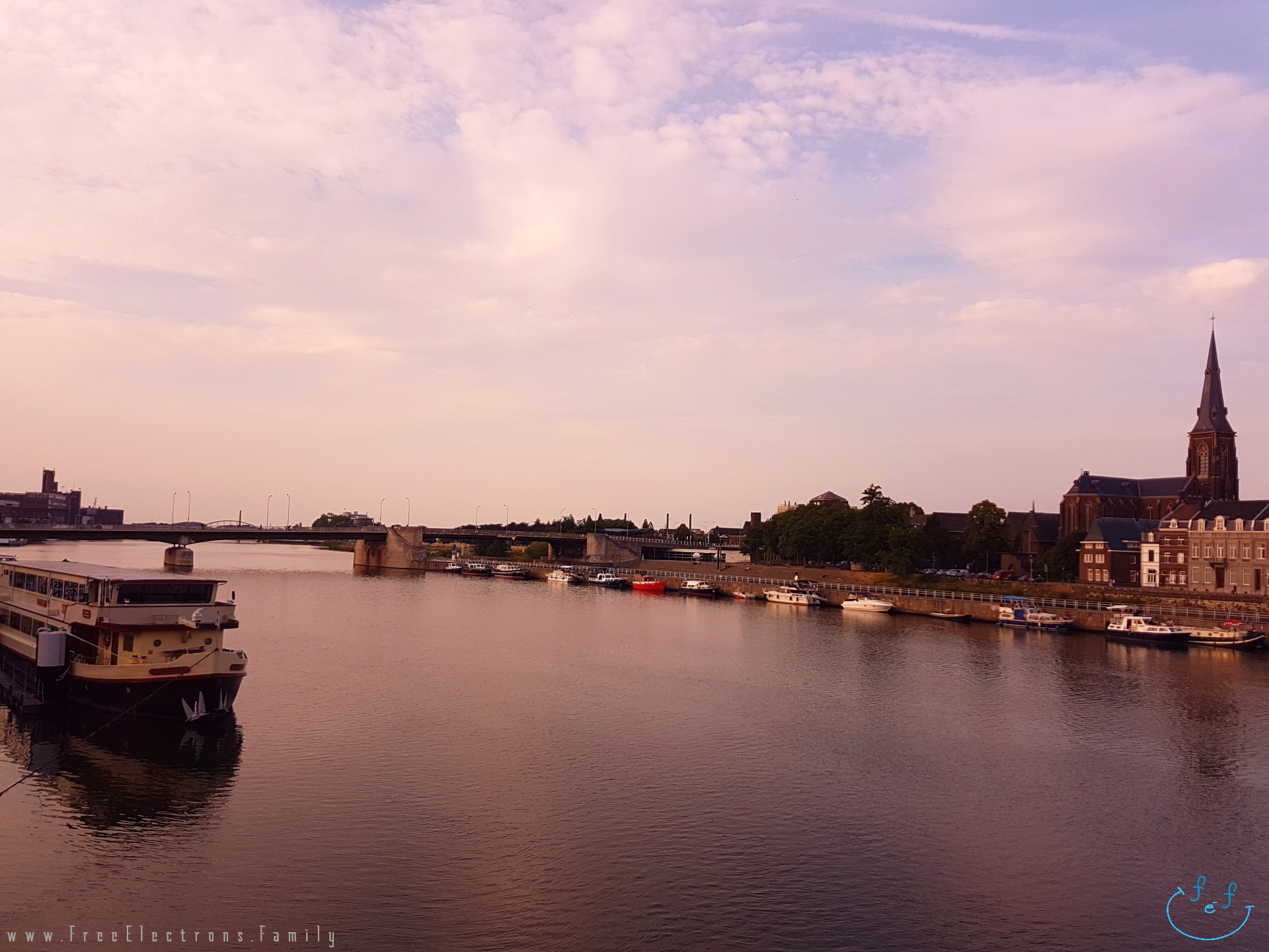 View of a river, boats and a church at dusk from Sint Servaasbrug (Saint Servatius) Bridge.

#FreeElectrons.Family - camping road trip Europe Maastricht