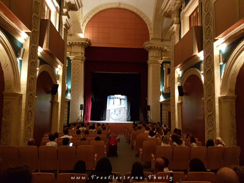 Indoor puppet show at an well-preserved historic theatre.

Caption reads:  The show must go on! In case of rain, the puppet shows would stay on schedule but move to indoor locations.  In this case. . . to Sala Compania (theater in the historic center of Jerez)... for the International Puppet Festival (Festival Internacional de Títeres) in September.

www.FreeElectrons.Family - what to do see in Jerez in September.