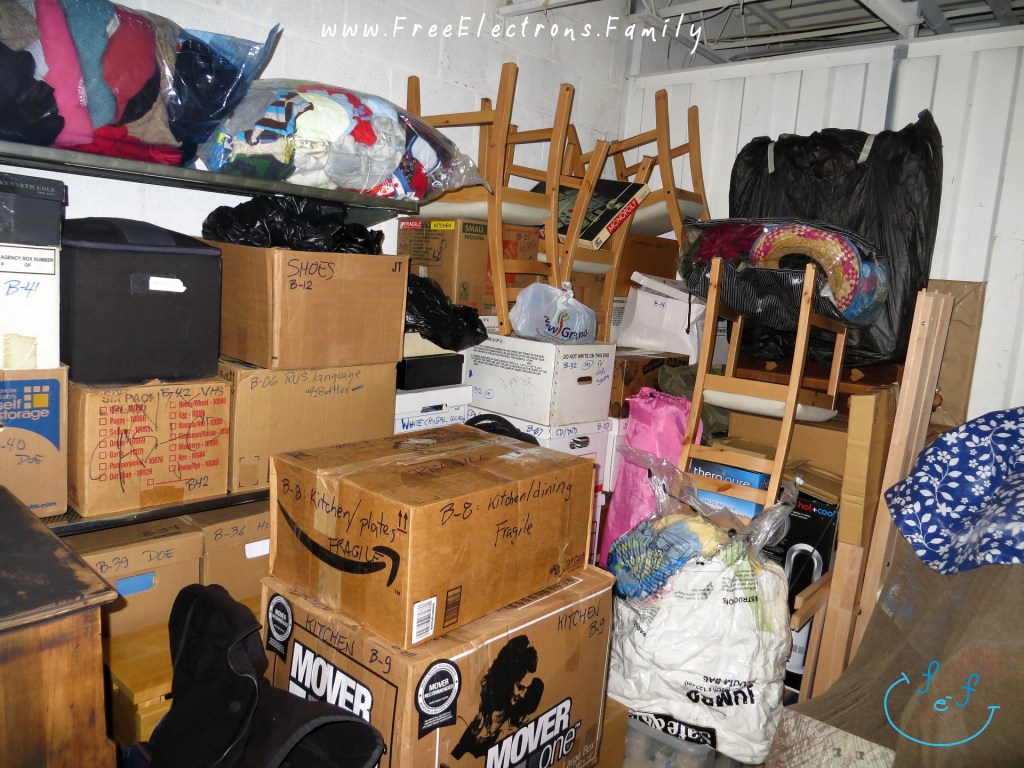 Inside a full storage unit with boxes and furniture.

Text:  www.FreeElectrons.Family