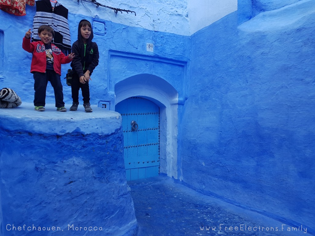 Two smiling young boys at a doorstep in Chefchaouen, Morocco where almost everything is blue.-Free Electrons Family