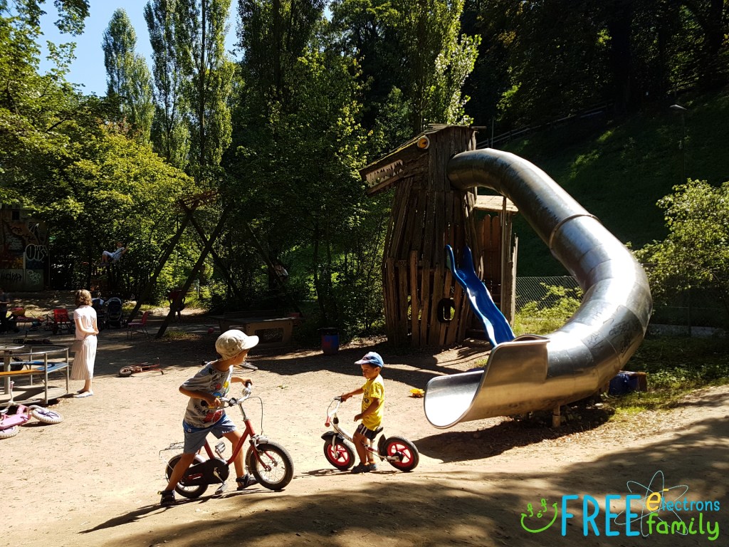 Young children on bicycles with a homemade dragon-slide at the Spielplatz Längmuur playground in Bern, Switzerland.
www.FreeElectrons.Family 