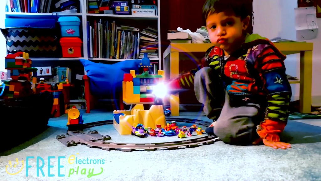 A young child playing with on the carpet with SuperZings with Lego Duplo toys with special flash effect. -Free Electrons FreePlay
