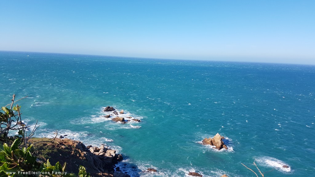 A rocky coastal cliff with sea view and rock outcrops.